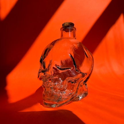 A close-up of a Laughing Dead MC Inc water bottle with a skull logo on a wooden table.