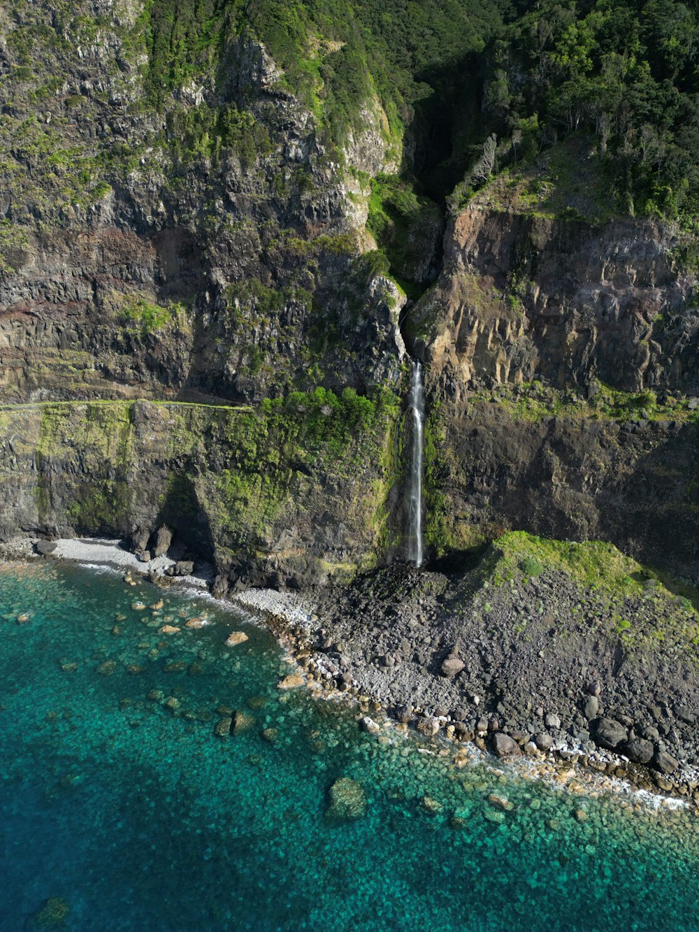 an aerial view of a waterfall in the middle of the ocean