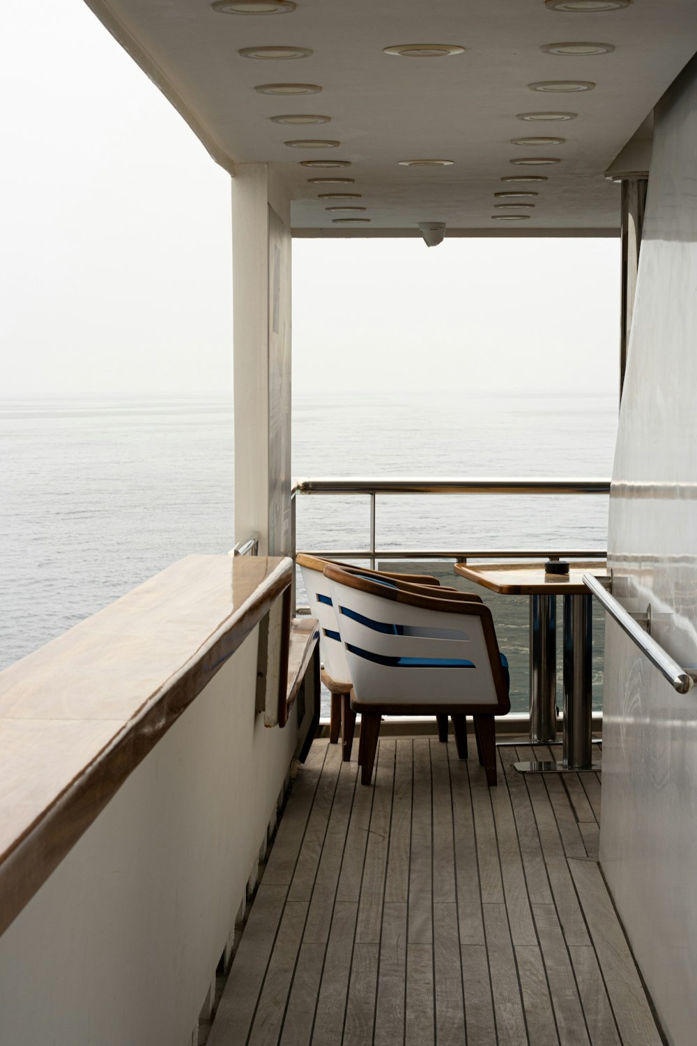 a balcony with a table and chairs overlooking the ocean