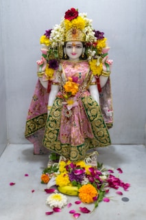 a statue of a woman with flowers around her