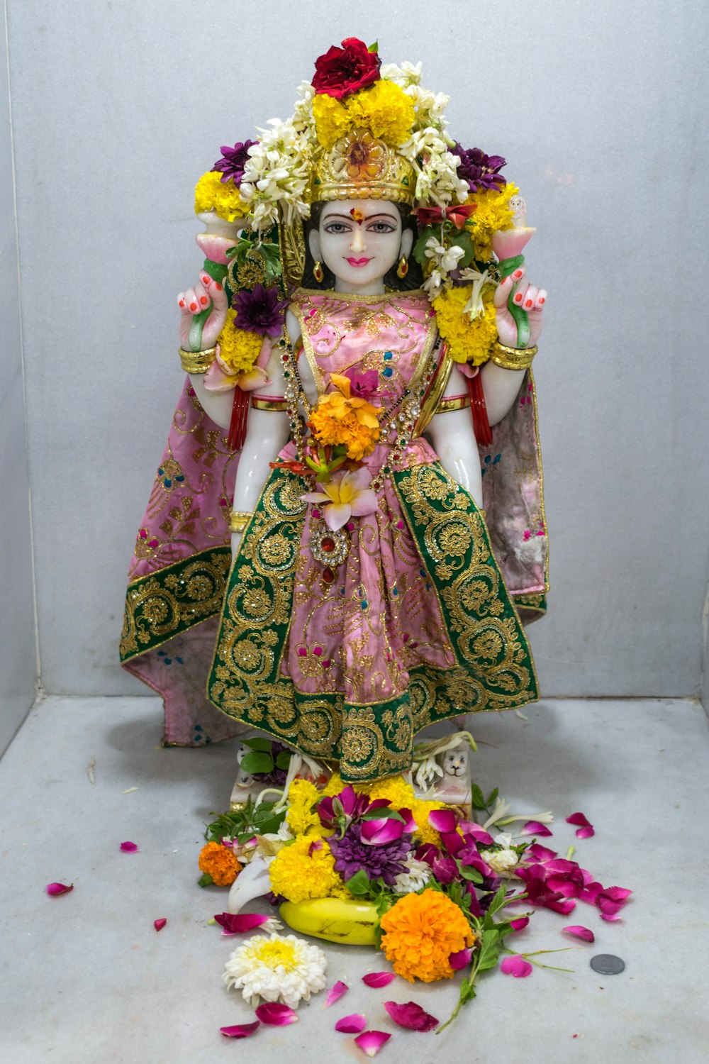 una statua di una donna con fiori intorno a lei