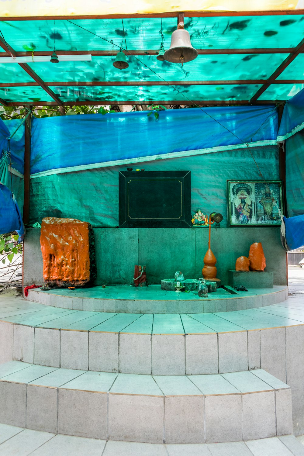 a blue covered area with steps and a painting on the wall
