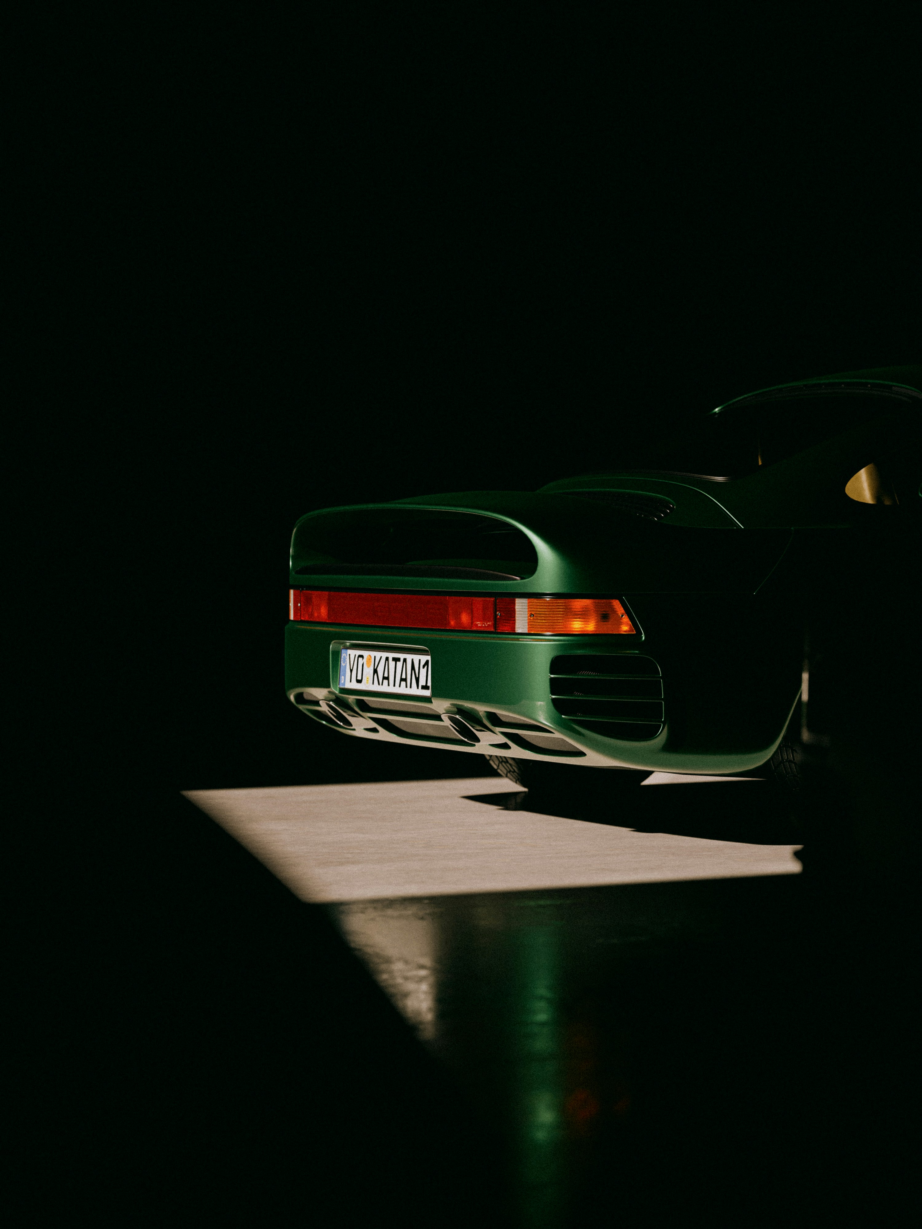 a green sports car parked in the dark
