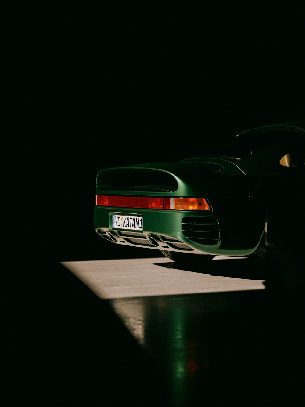 a green sports car parked in the dark