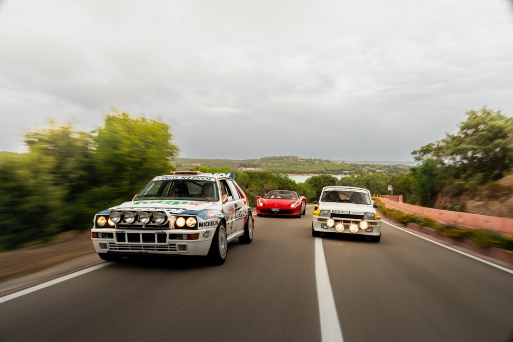 a couple of cars driving down a road next to each other