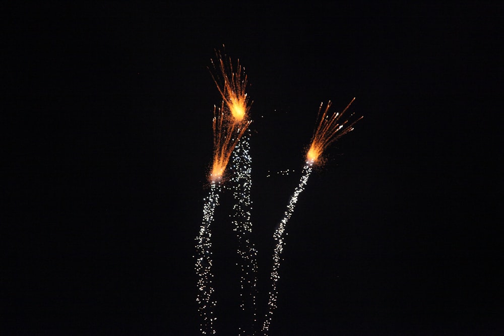 a couple of fireworks are lit up in the dark