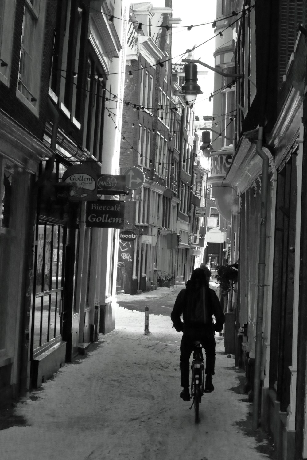 a man riding a bike down a snow covered street