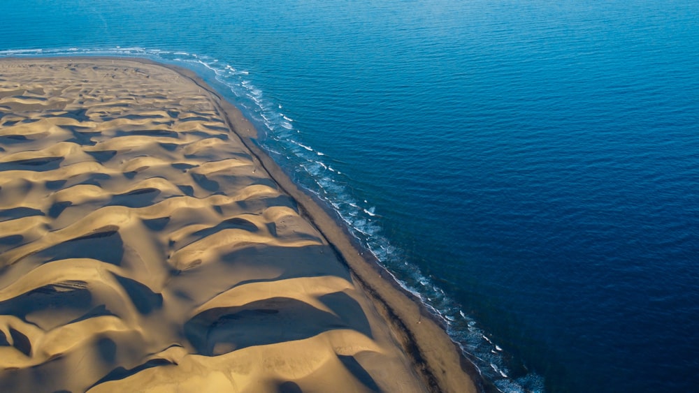 an aerial view of a sandy beach near the ocean