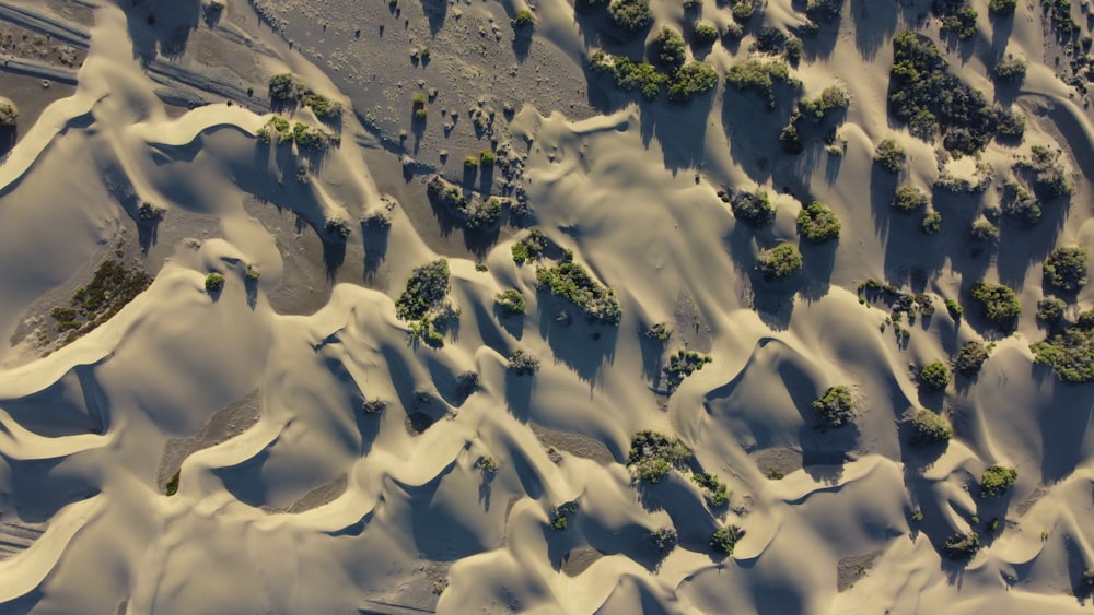 an aerial view of snow covered hills and trees