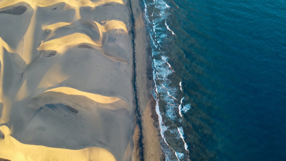 an aerial view of a sandy beach near the ocean