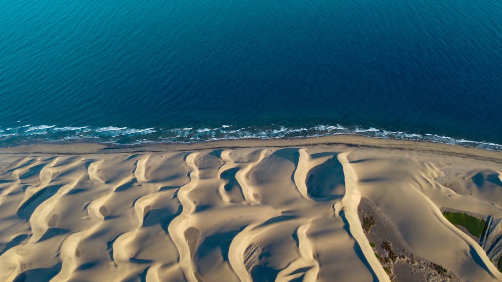 an aerial view of a sandy beach and ocean