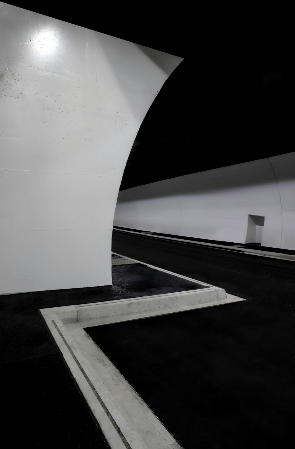 a very long white tunnel with a black floor