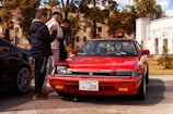 A group of car enthusiasts gathered around a classic JDM vehicle.