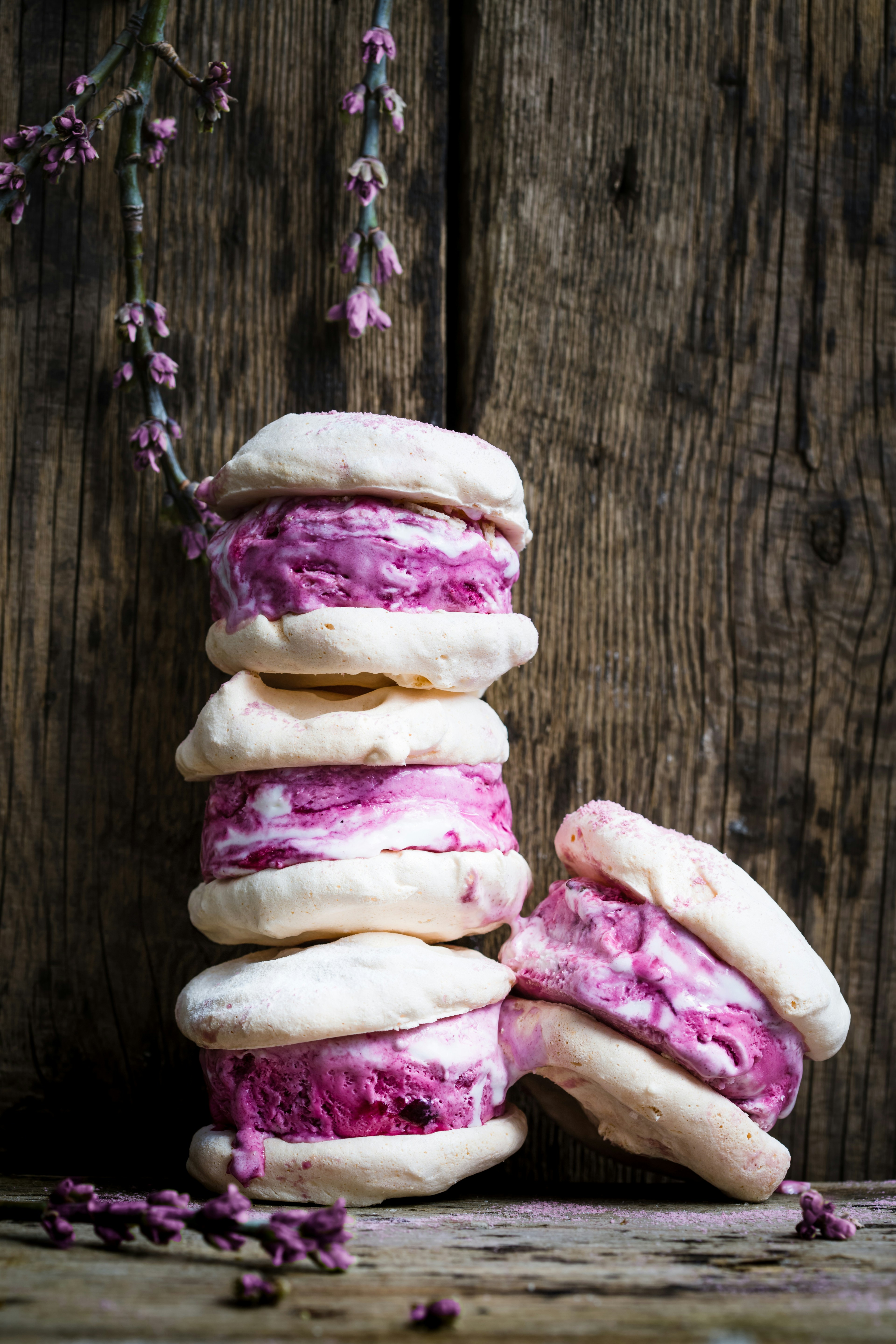 a stack of pink and white cookies sitting on top of a wooden table