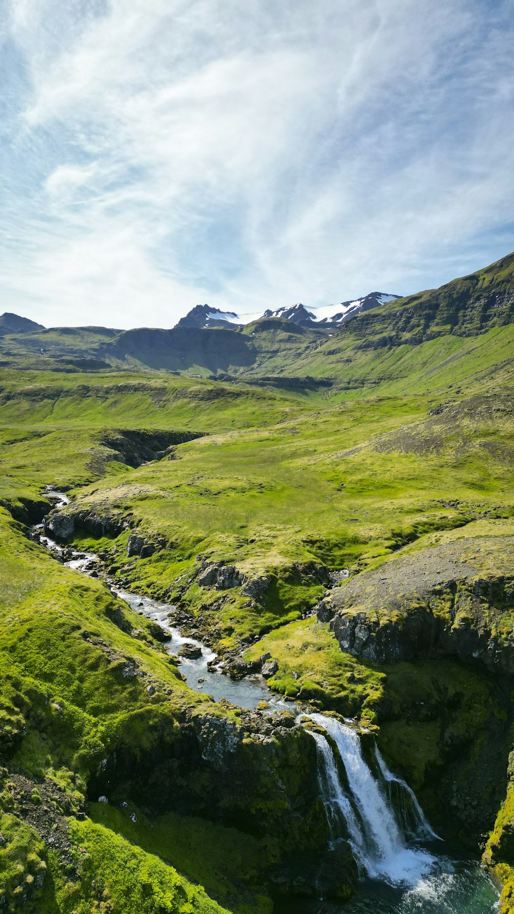 a stream running through a lush green valley