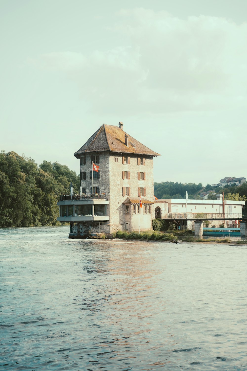 a building sitting on top of a river next to a bridge