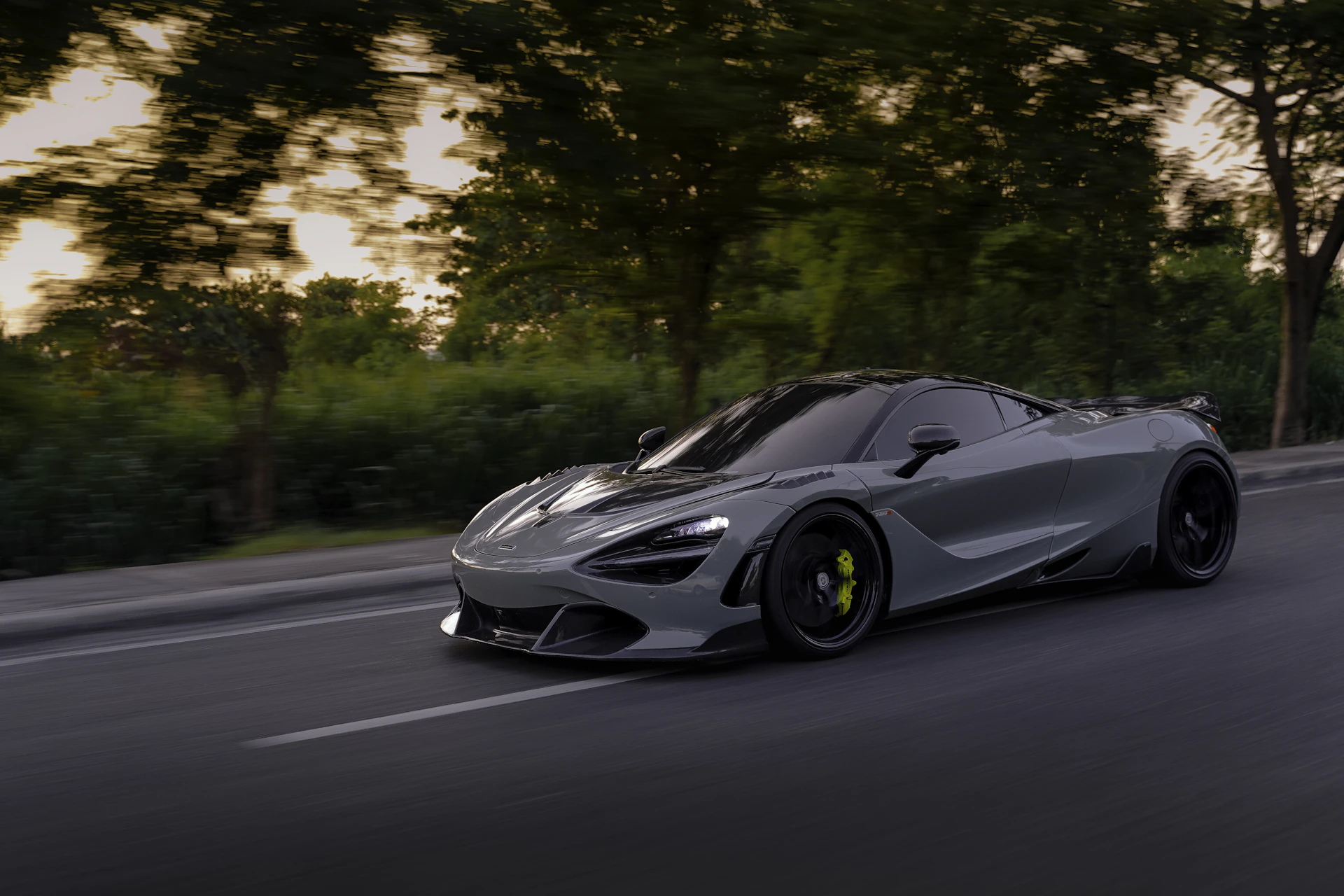 a silver sports car driving down a street