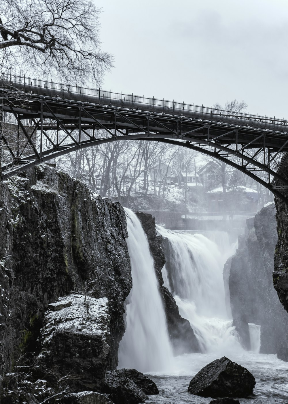 a bridge over a river with a waterfall below