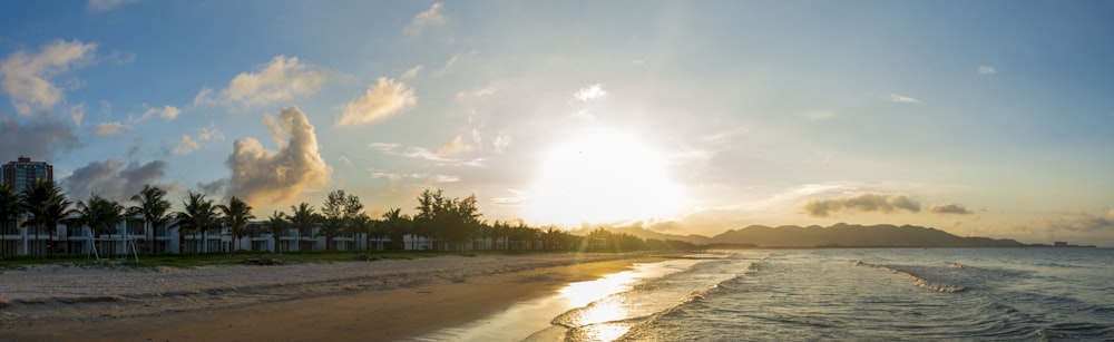 the sun is setting over the beach and the water