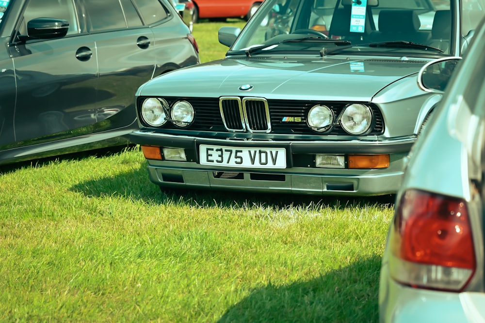 a group of cars parked on top of a lush green field