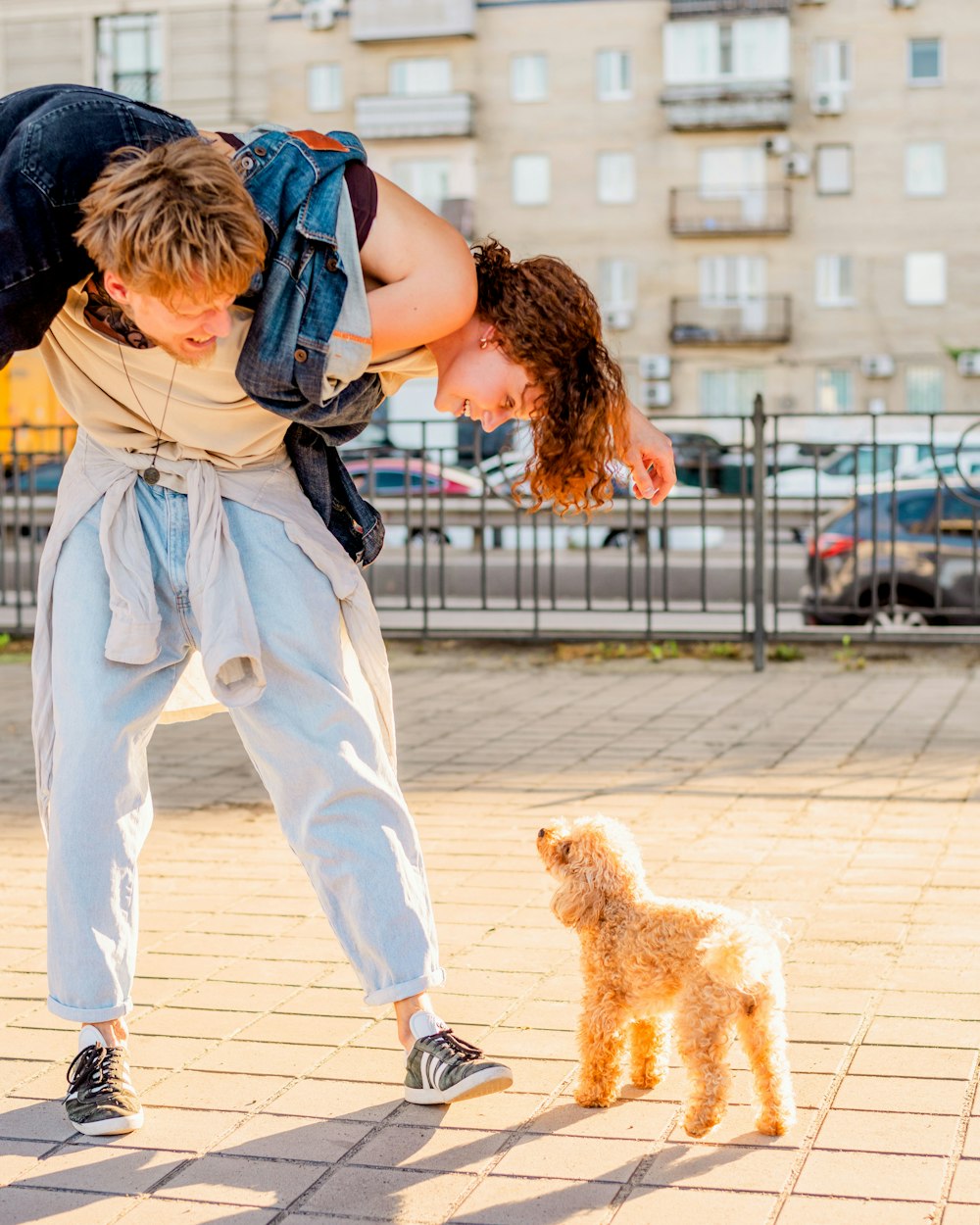 a man is bending over to pet a small dog