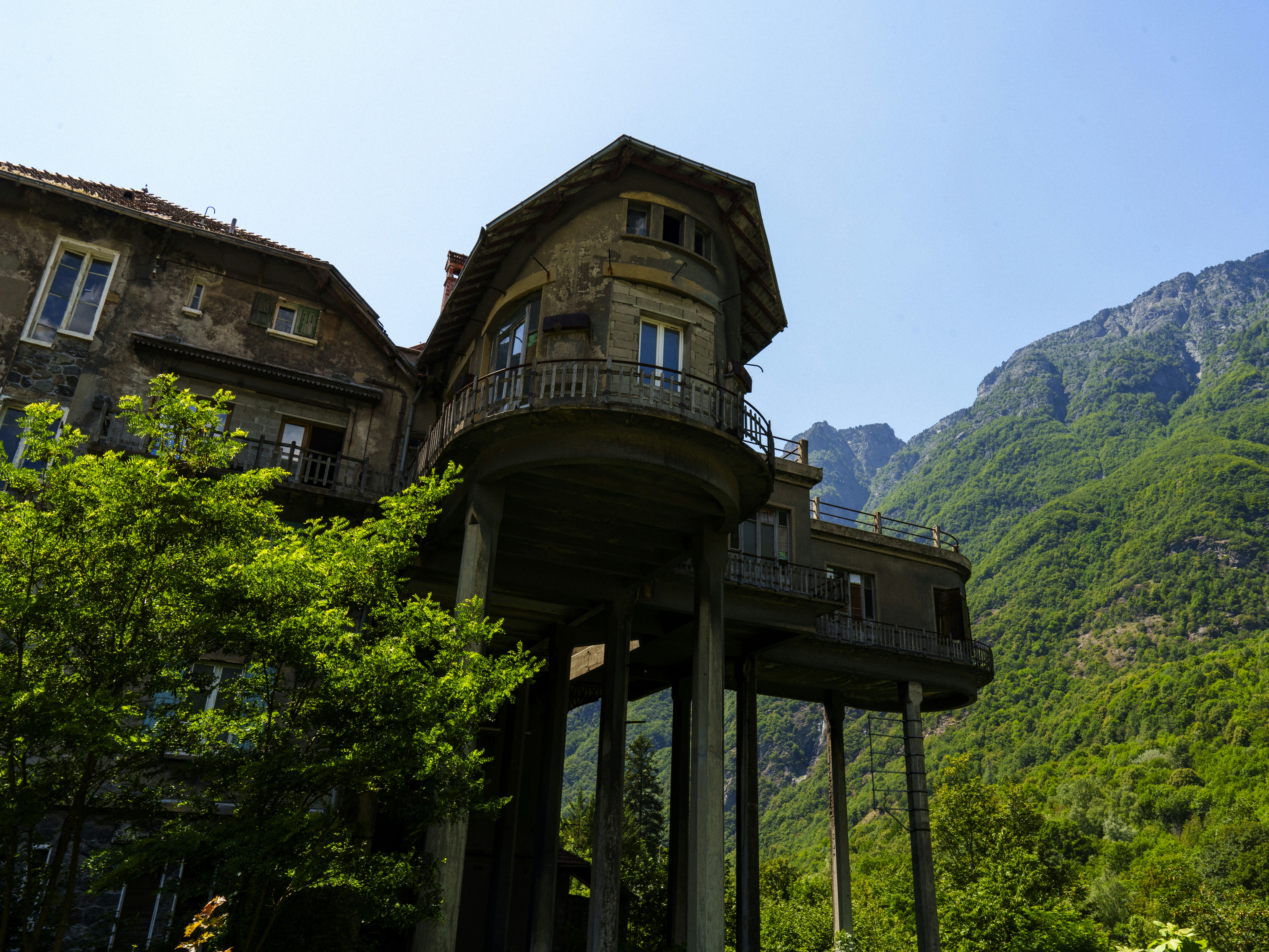 a tall building with a balcony and balcony balconies in front of a mountain