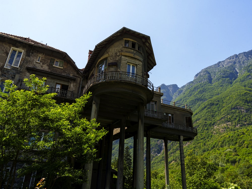 Un edificio alto con balcón y balcones frente a una montaña