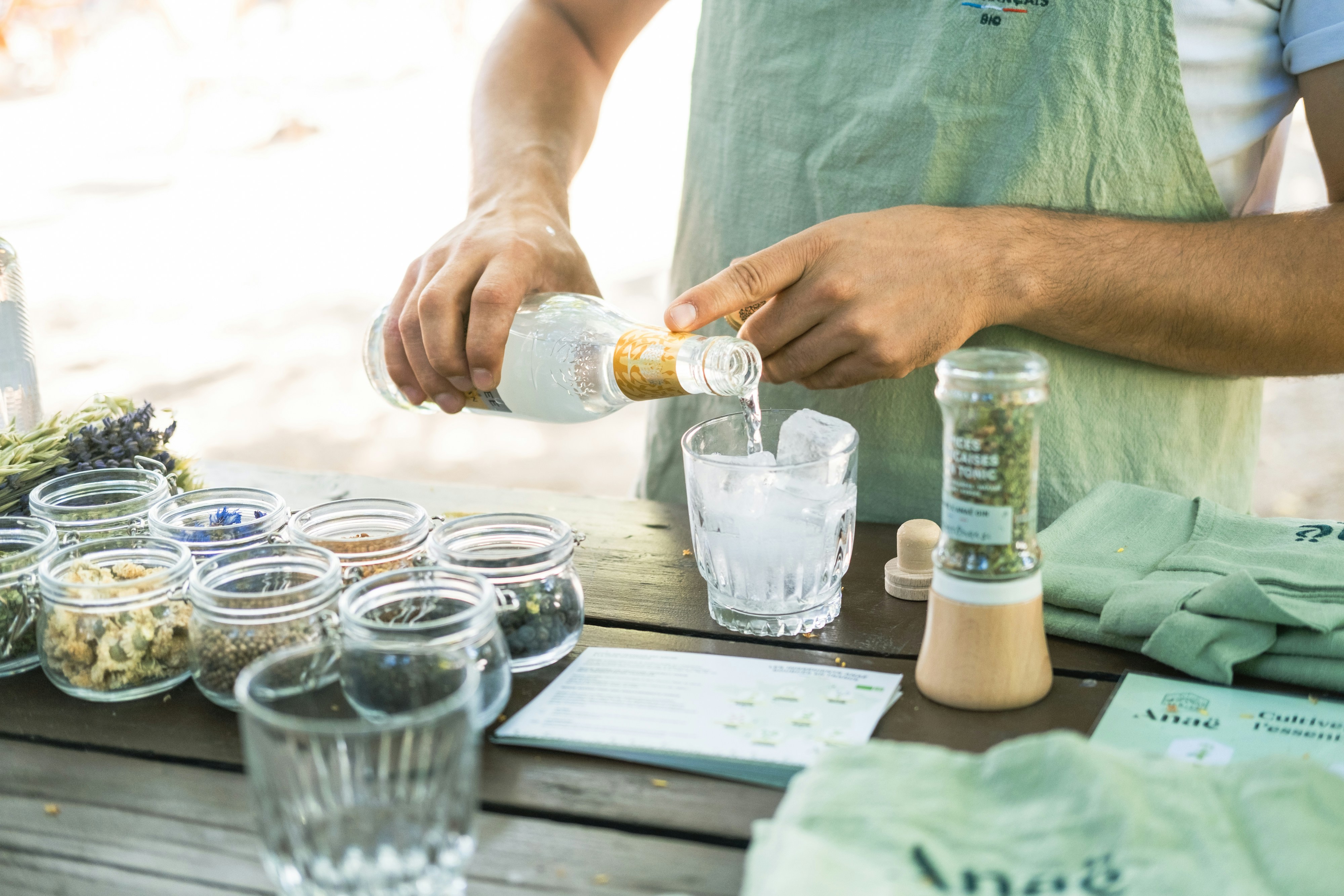 a man pours a drink from a bottle into a glass