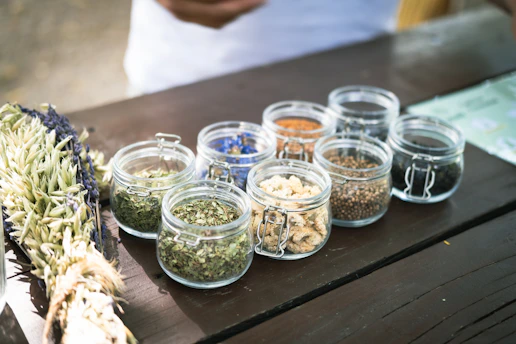 a wooden table topped with glass jars filled with food