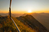 Close-up of balcony railing framing the scenic mountain valley at sunset.