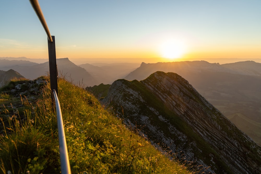 the sun is setting over a mountain range