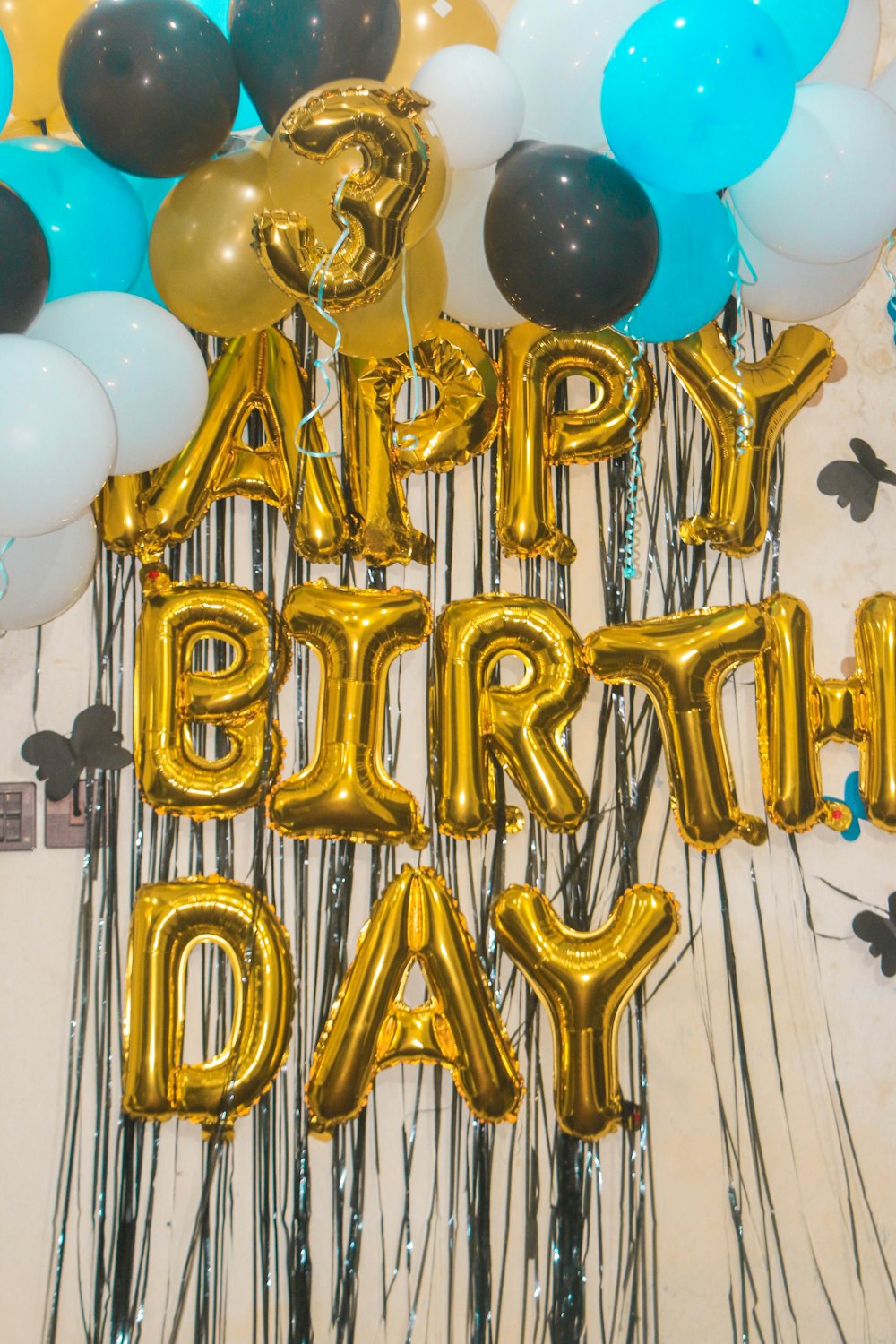 Un montón de globos que dicen feliz cumpleaños