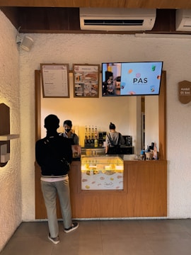 A small local café with a digital assistant screen showing AI-powered order taking.