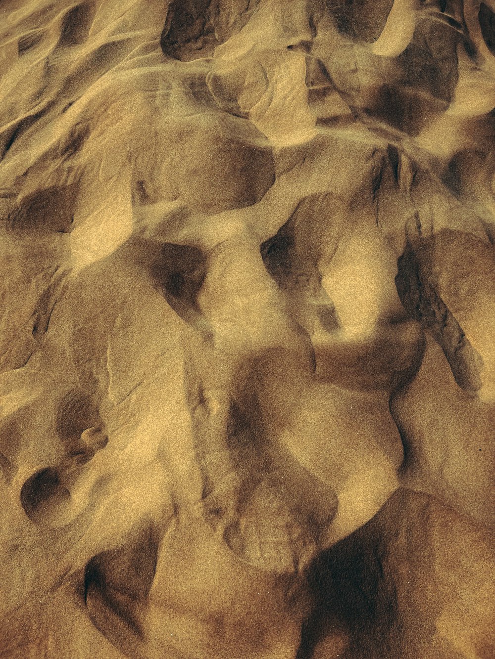 a close up of sand and rocks with a sky background