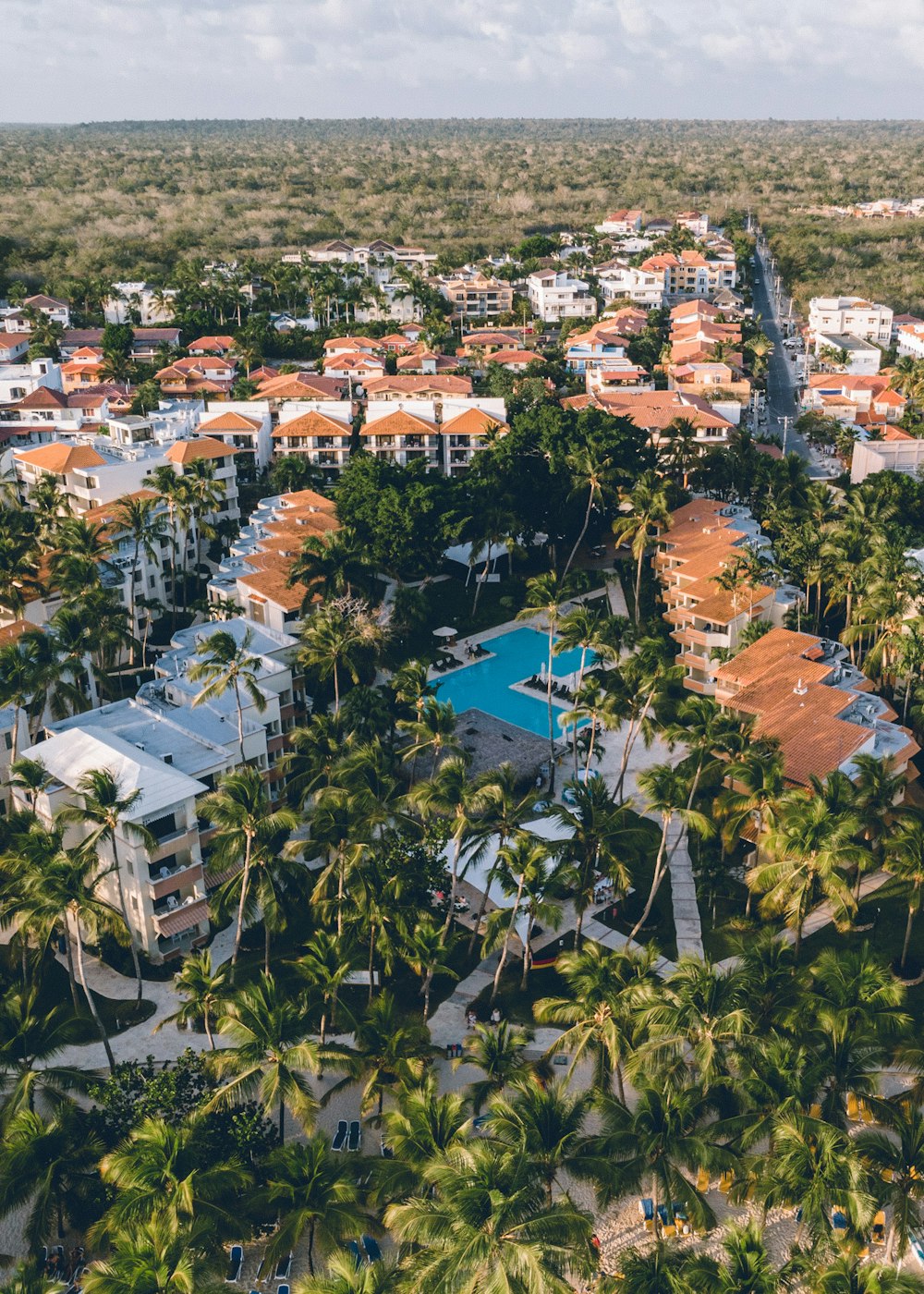 an aerial view of a resort surrounded by palm trees