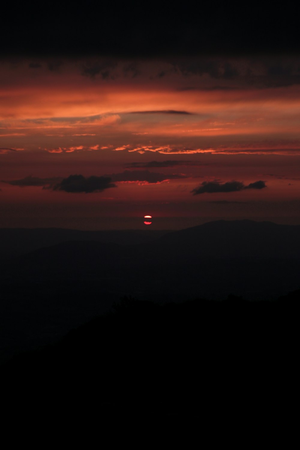 the sun is setting over a mountain range