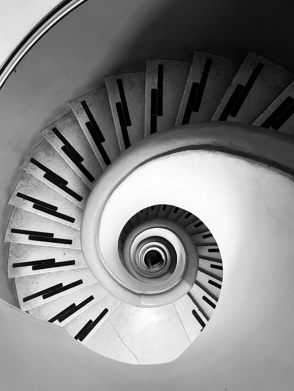 a black and white photo of a spiral staircase