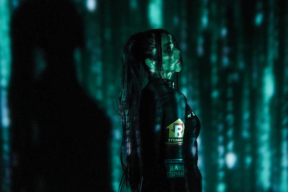 a woman with long hair standing in a dark room