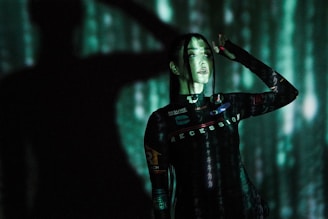 A model wearing a futuristic 3D-patterned t-shirt standing against a minimalist urban backdrop.