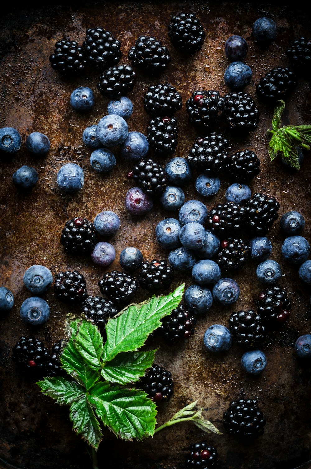 berries and mint on a pan with a green leaf