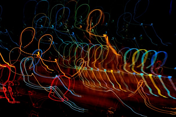 A dynamic display of colorful, looping light trails against a dark background, creating an abstract, energetic pattern with a sense of motion.