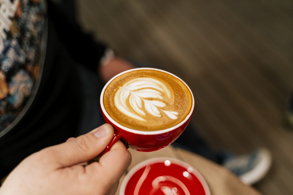 a person holding a cup of coffee in their hand