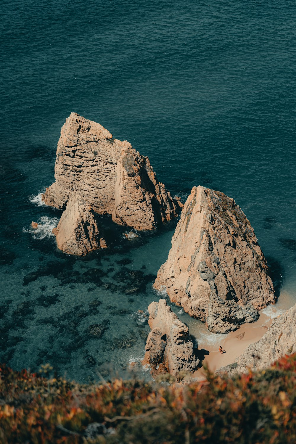 a couple of large rocks sitting on top of a beach