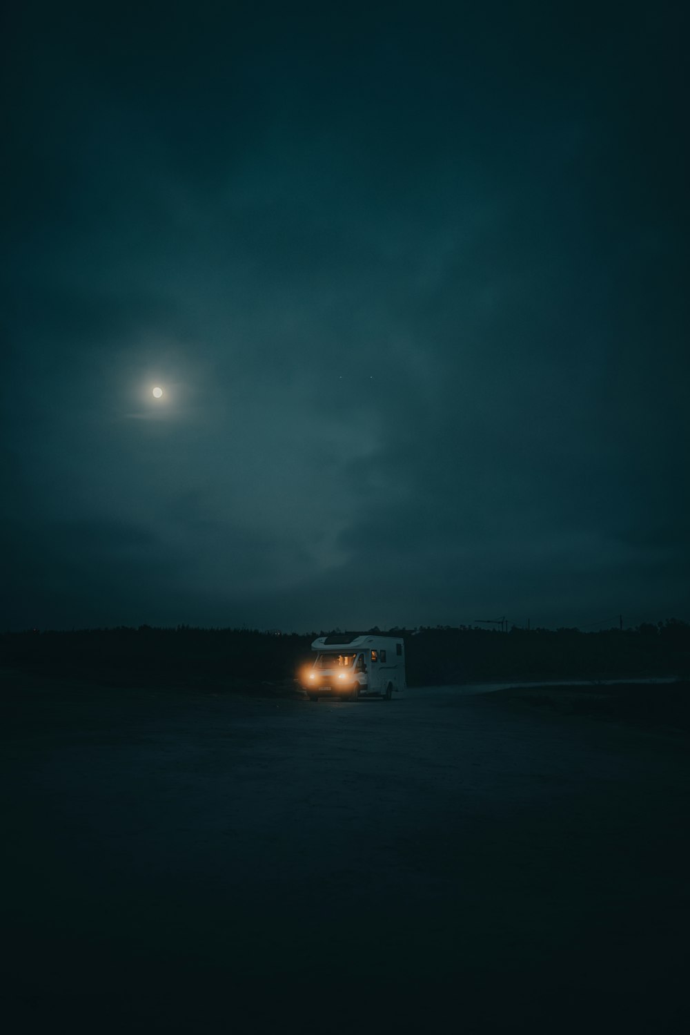a truck driving down a dark road at night