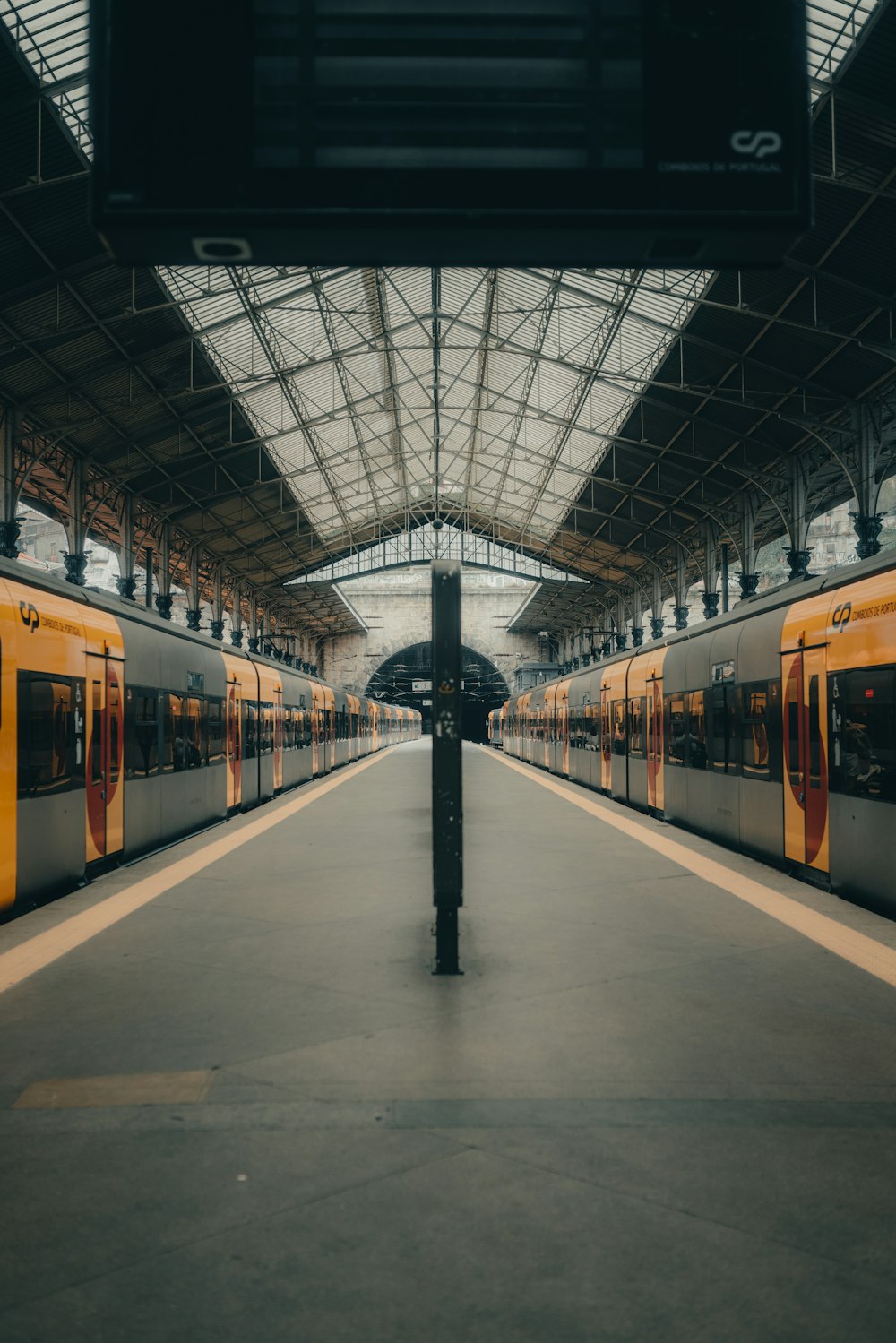 a train station with two trains parked inside of it