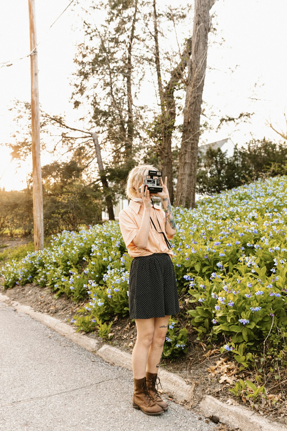 a woman taking a picture of flowers with a camera