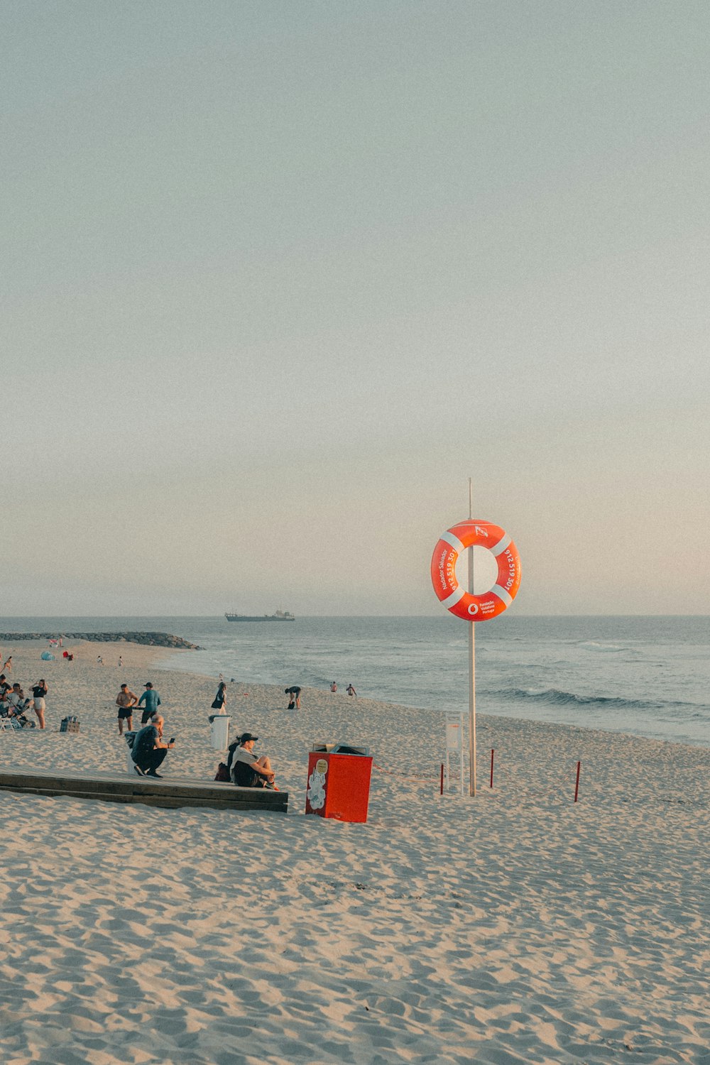 a group of people sitting on top of a sandy beach