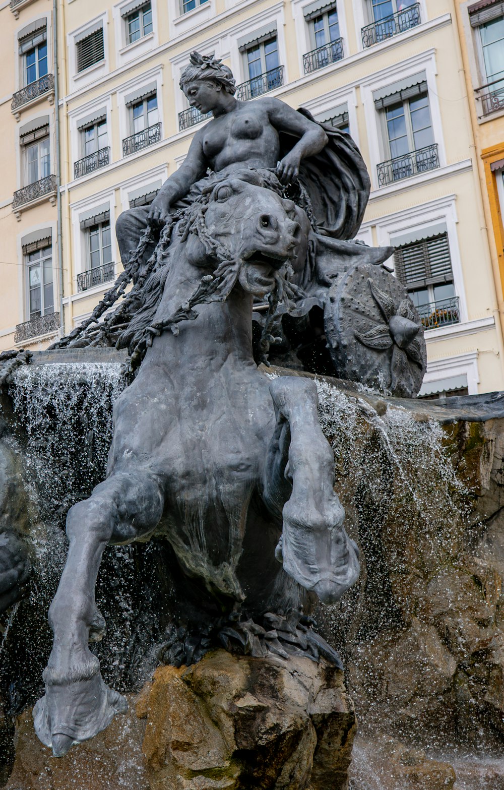 a statue of a man riding a horse in front of a building