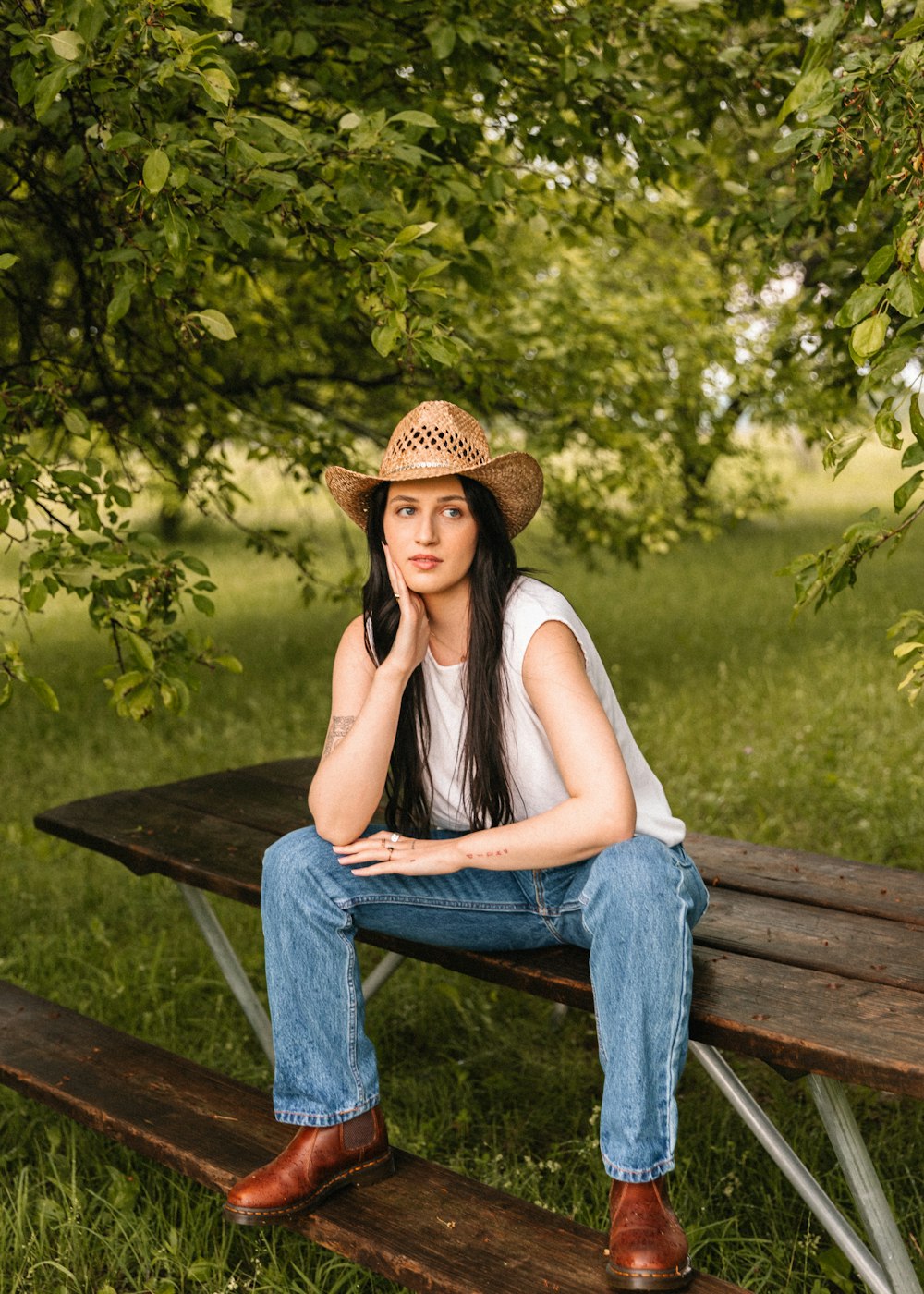 a woman sitting on a bench in the grass