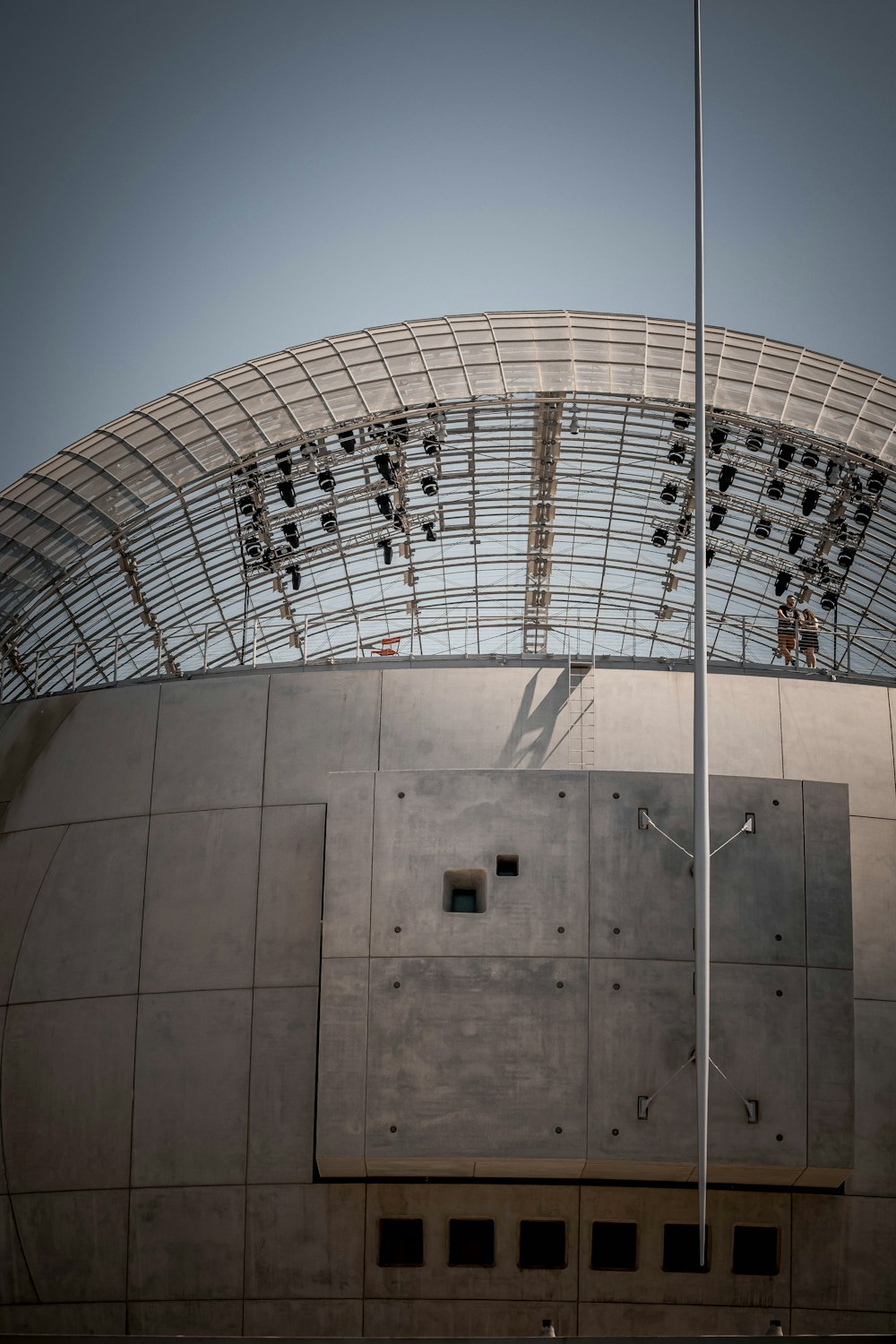 a large metal structure with a flag pole in front of it